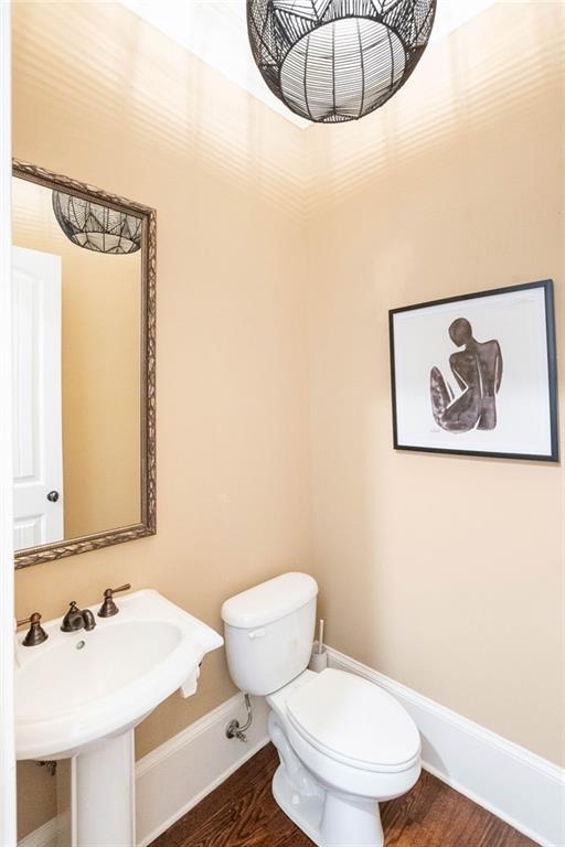 bathroom featuring toilet, hardwood / wood-style flooring, and sink