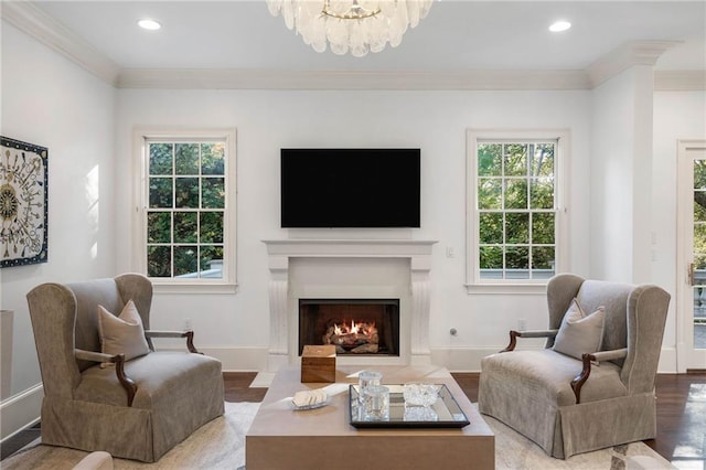 living room featuring light hardwood / wood-style flooring, ornamental molding, and a notable chandelier