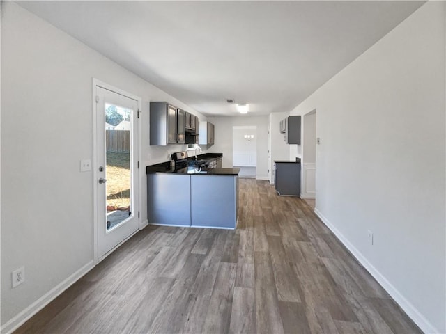 kitchen with dark hardwood / wood-style flooring, kitchen peninsula, and range