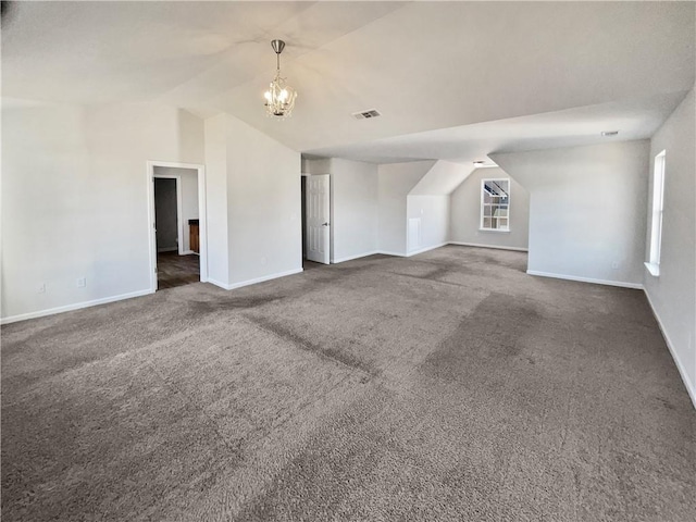 additional living space with lofted ceiling, a notable chandelier, and dark carpet