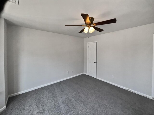 empty room with ceiling fan and dark colored carpet