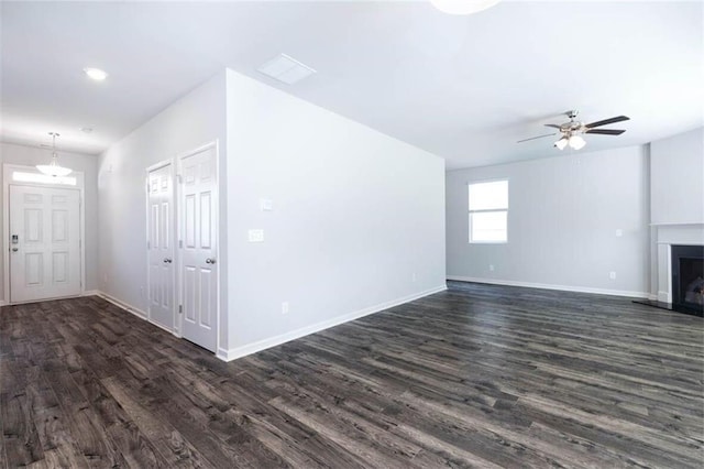 unfurnished living room with ceiling fan and dark hardwood / wood-style floors