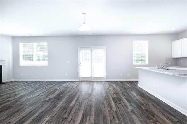 unfurnished living room featuring dark hardwood / wood-style floors and sink