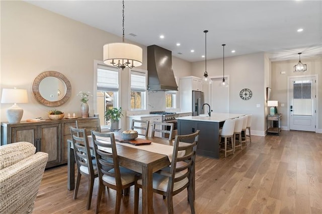 dining room with a chandelier, light wood-type flooring, and sink