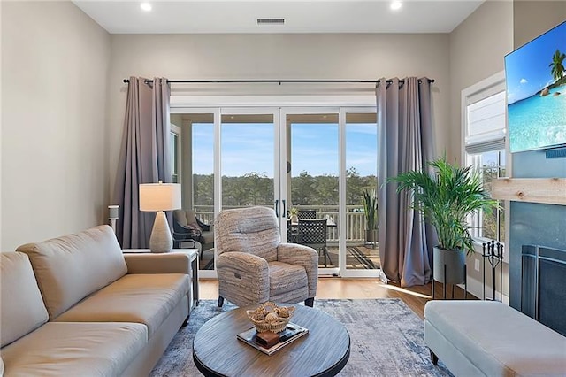 living room with recessed lighting, visible vents, wood finished floors, and a fireplace