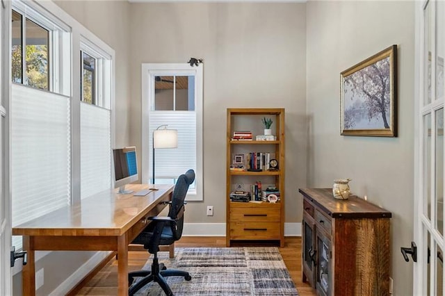 home office with french doors and hardwood / wood-style flooring