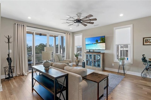 living room with ceiling fan and light hardwood / wood-style floors