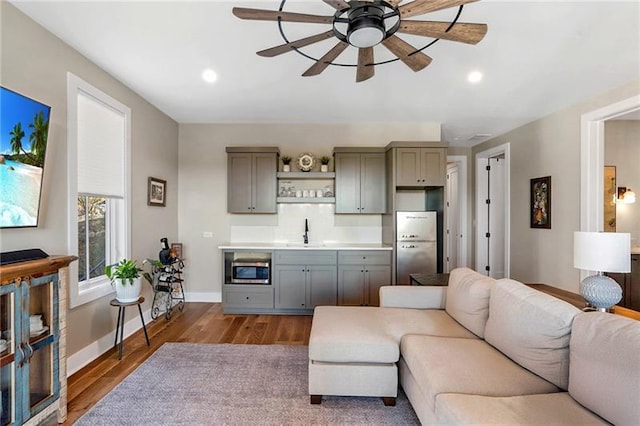 living area with dark wood-style floors, recessed lighting, a ceiling fan, and baseboards