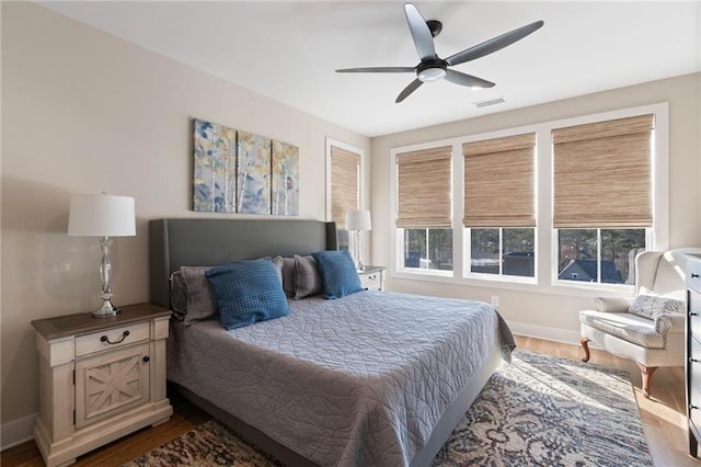 bedroom featuring visible vents, baseboards, dark wood-type flooring, and a ceiling fan