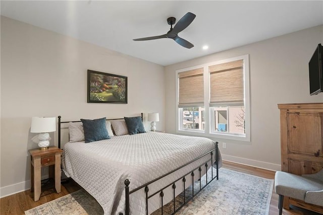 bedroom with ceiling fan, baseboards, and wood finished floors