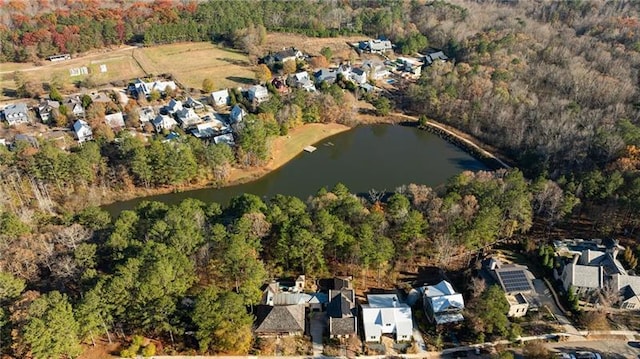 birds eye view of property with a forest view, a water view, and a residential view