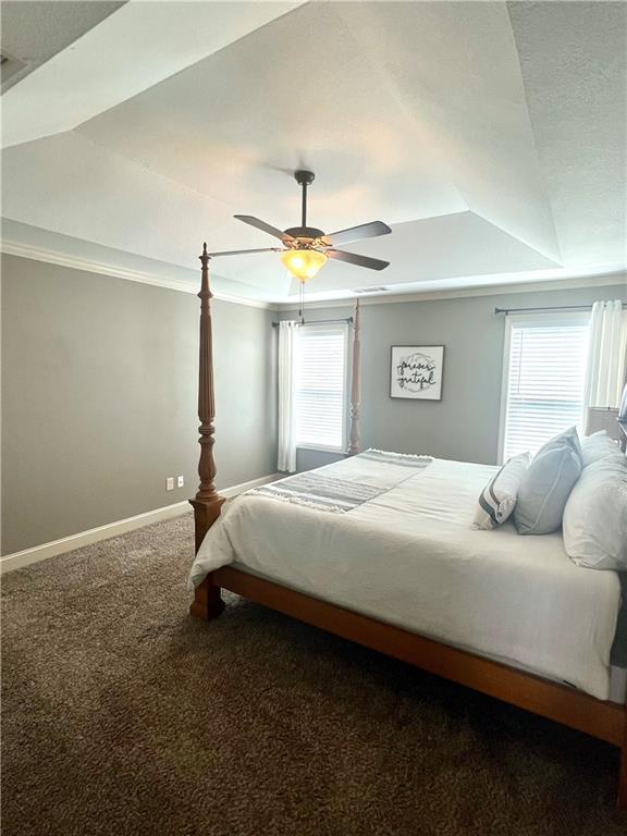 bedroom featuring baseboards, multiple windows, carpet flooring, and ceiling fan