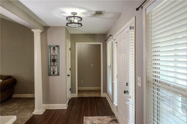 hallway with baseboards, visible vents, plenty of natural light, and wood finished floors