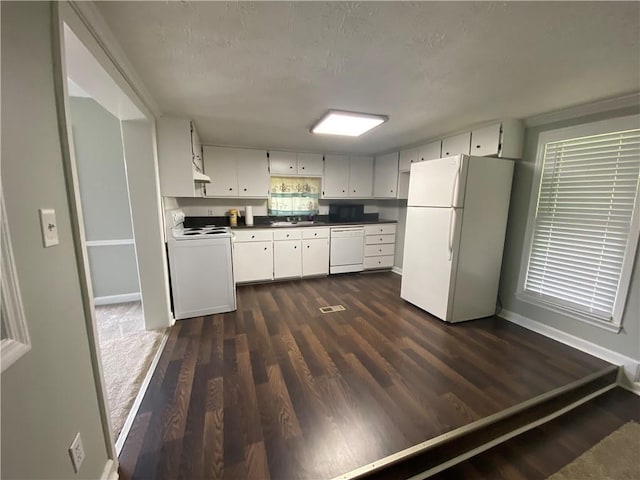 kitchen with white appliances, dark wood-type flooring, a textured ceiling, white cabinets, and sink