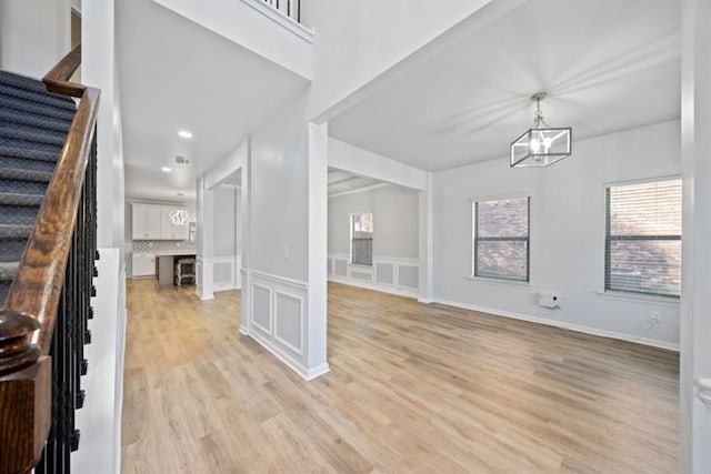 foyer entrance with light hardwood / wood-style flooring and a notable chandelier