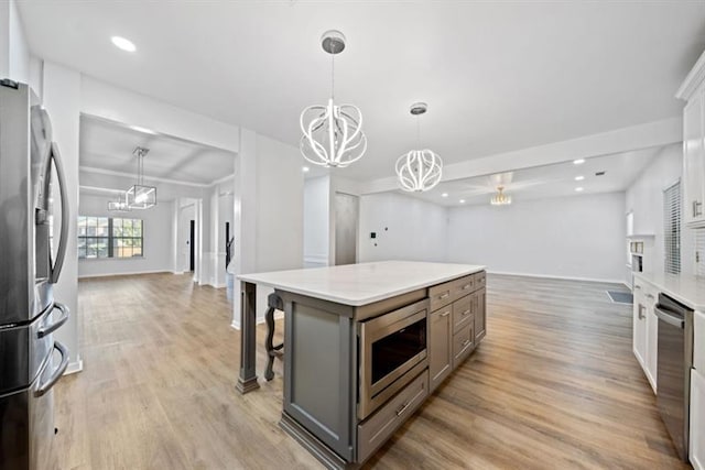 kitchen with a center island, appliances with stainless steel finishes, a breakfast bar, and pendant lighting