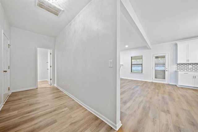 interior space featuring vaulted ceiling and light hardwood / wood-style flooring