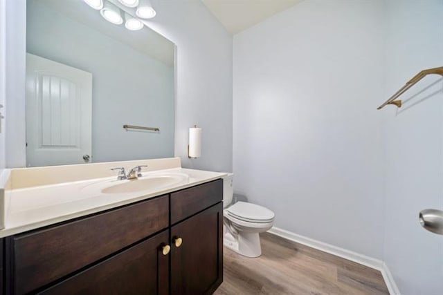 bathroom featuring hardwood / wood-style floors, vanity, and toilet