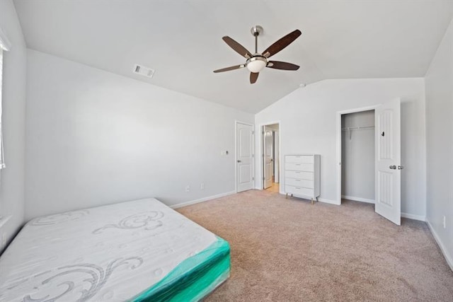 carpeted bedroom with ceiling fan, vaulted ceiling, and a closet