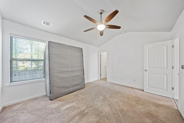 carpeted spare room featuring ceiling fan and lofted ceiling