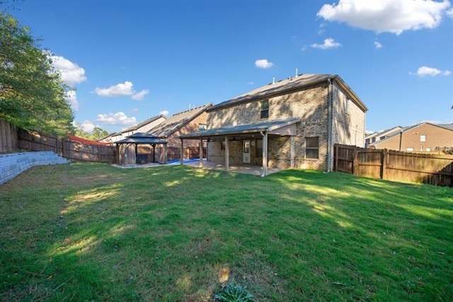 back of house with a gazebo and a lawn