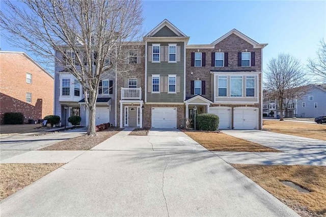townhome / multi-family property with a garage, brick siding, and concrete driveway