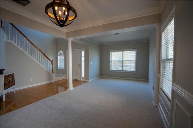 foyer featuring carpet, ornate columns, visible vents, stairway, and baseboards