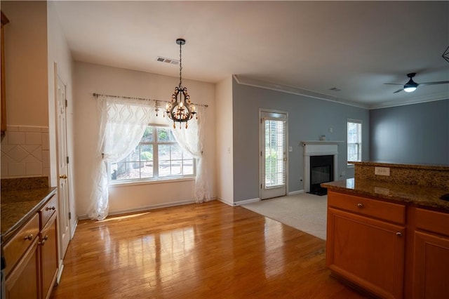 unfurnished dining area featuring visible vents, a wealth of natural light, light wood-style floors, and baseboards