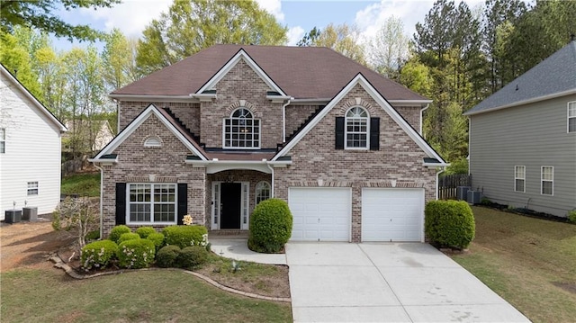 traditional-style home featuring brick siding, a front yard, a garage, and concrete driveway