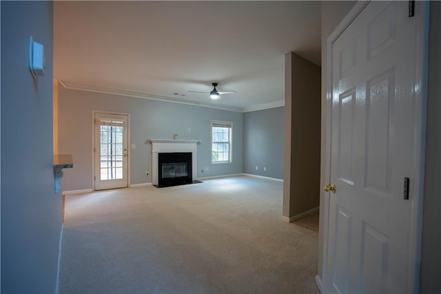 unfurnished living room featuring crown molding, carpet, a fireplace with flush hearth, a ceiling fan, and baseboards