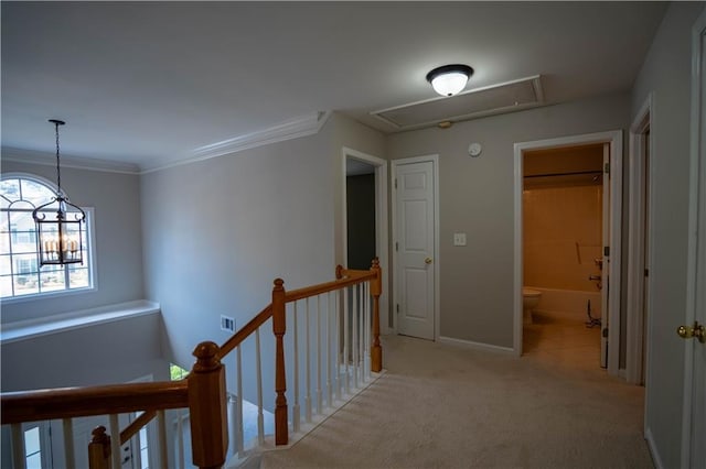 corridor featuring ornamental molding, light carpet, an upstairs landing, attic access, and visible vents
