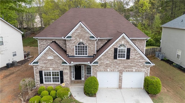 view of front of property featuring driveway, central AC unit, and brick siding