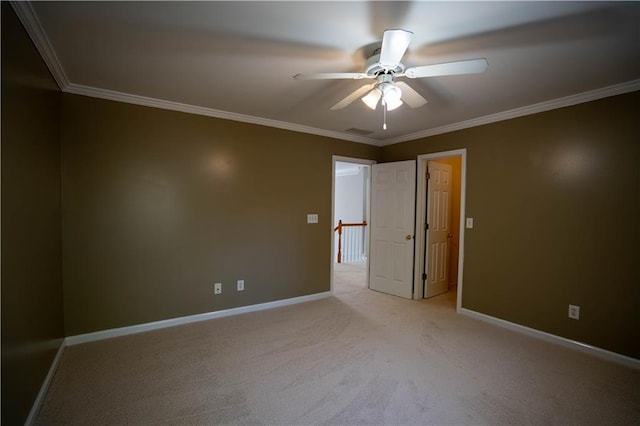 empty room with visible vents, light colored carpet, a ceiling fan, and ornamental molding