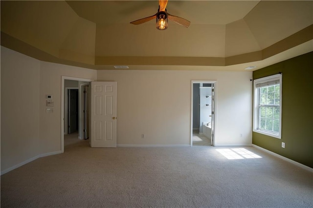 spare room featuring light colored carpet, baseboards, and a ceiling fan