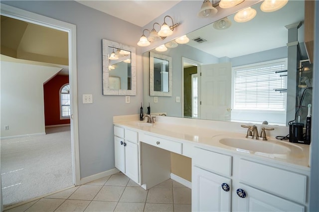 full bath featuring baseboards, double vanity, a sink, and visible vents