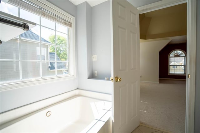 bathroom featuring a bath and baseboards