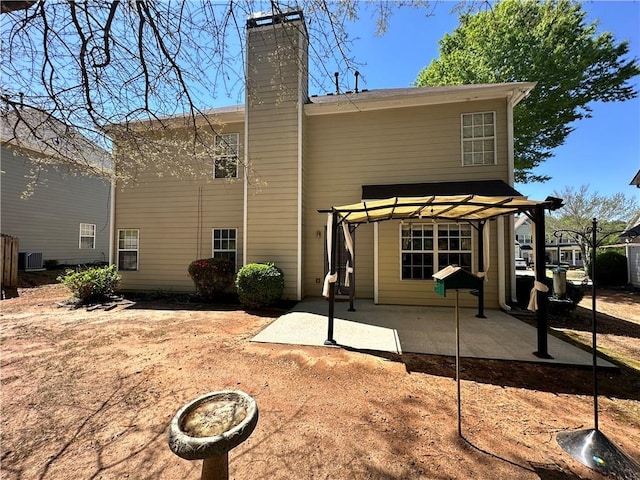 rear view of property featuring a patio, a chimney, a pergola, and central AC