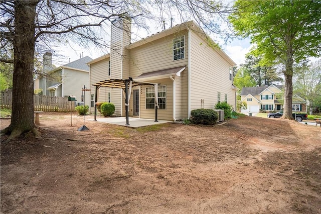 rear view of house featuring a patio area, fence, and a chimney