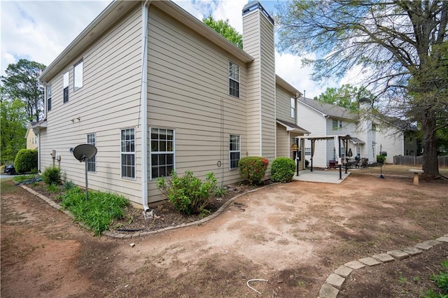 view of property exterior featuring a patio and a chimney