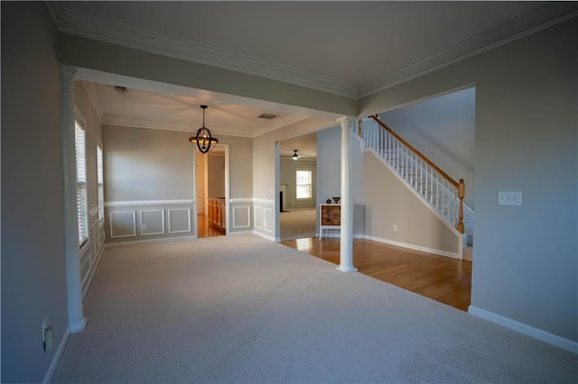 unfurnished living room with crown molding, carpet floors, decorative columns, and a healthy amount of sunlight