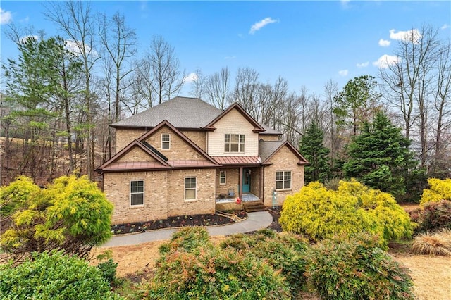 craftsman inspired home with metal roof, brick siding, and a standing seam roof