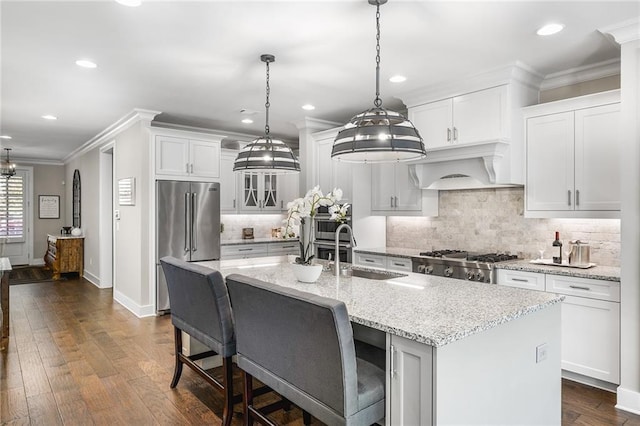 kitchen with a center island with sink, sink, premium range hood, and dark wood-type flooring