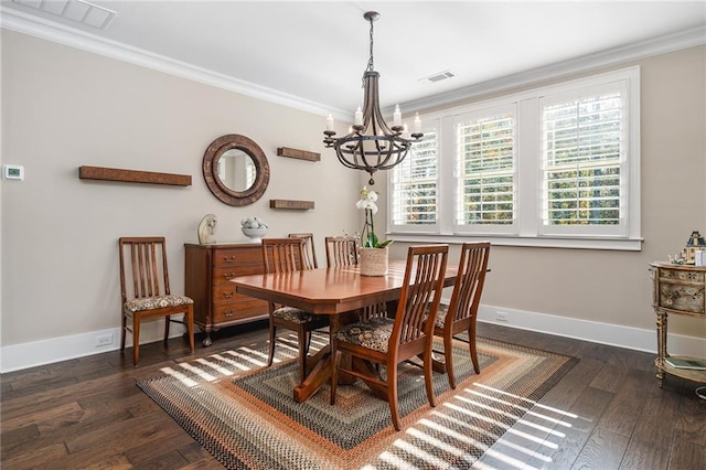 dining room with dark hardwood / wood-style floors, crown molding, and an inviting chandelier