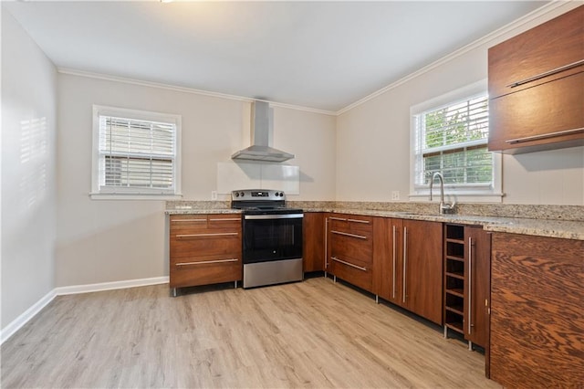 kitchen with a healthy amount of sunlight, electric range, light hardwood / wood-style flooring, and wall chimney exhaust hood