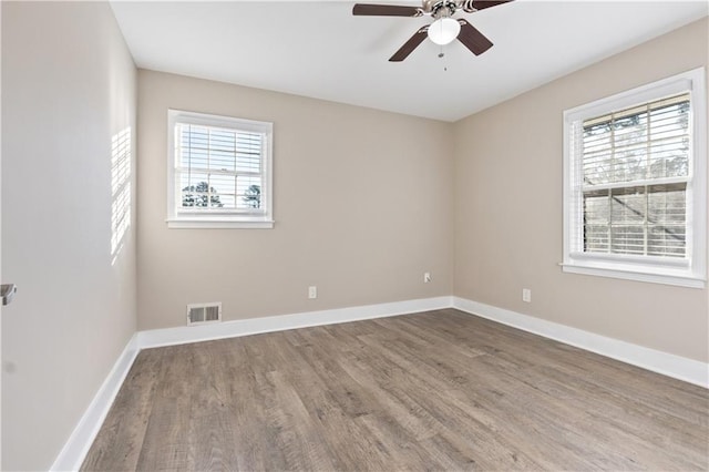 unfurnished room featuring ceiling fan, plenty of natural light, and hardwood / wood-style flooring