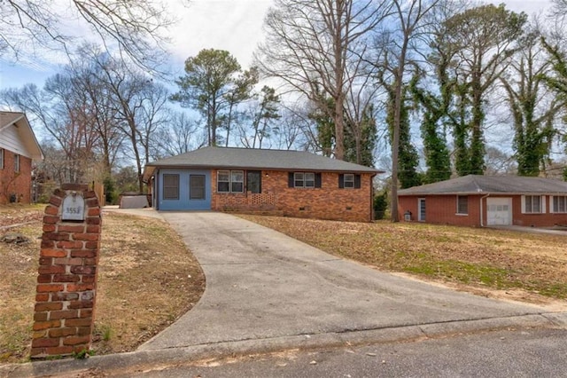 single story home featuring crawl space, brick siding, and concrete driveway