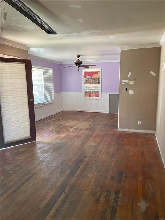 spare room with ceiling fan, hardwood / wood-style flooring, wainscoting, and ornamental molding