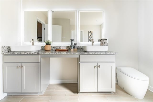 bathroom with a sink, tile patterned floors, and double vanity