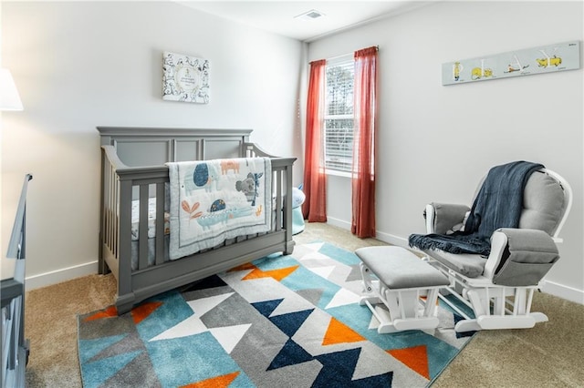 bedroom featuring carpet floors, baseboards, a crib, and visible vents