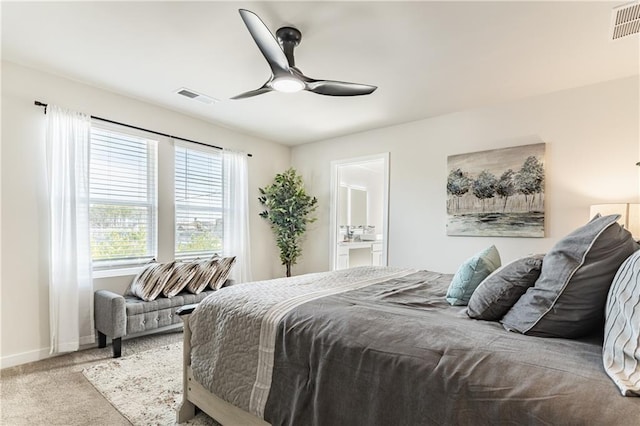 carpeted bedroom featuring baseboards, ensuite bathroom, a ceiling fan, and visible vents